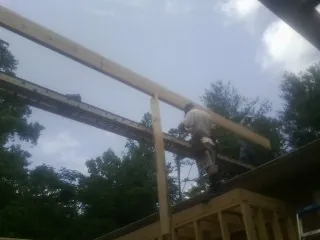 Carpenter setting a ridge beam over a new addition frame — Ice Dam Removal by Roofing Brothers in Lake Mills