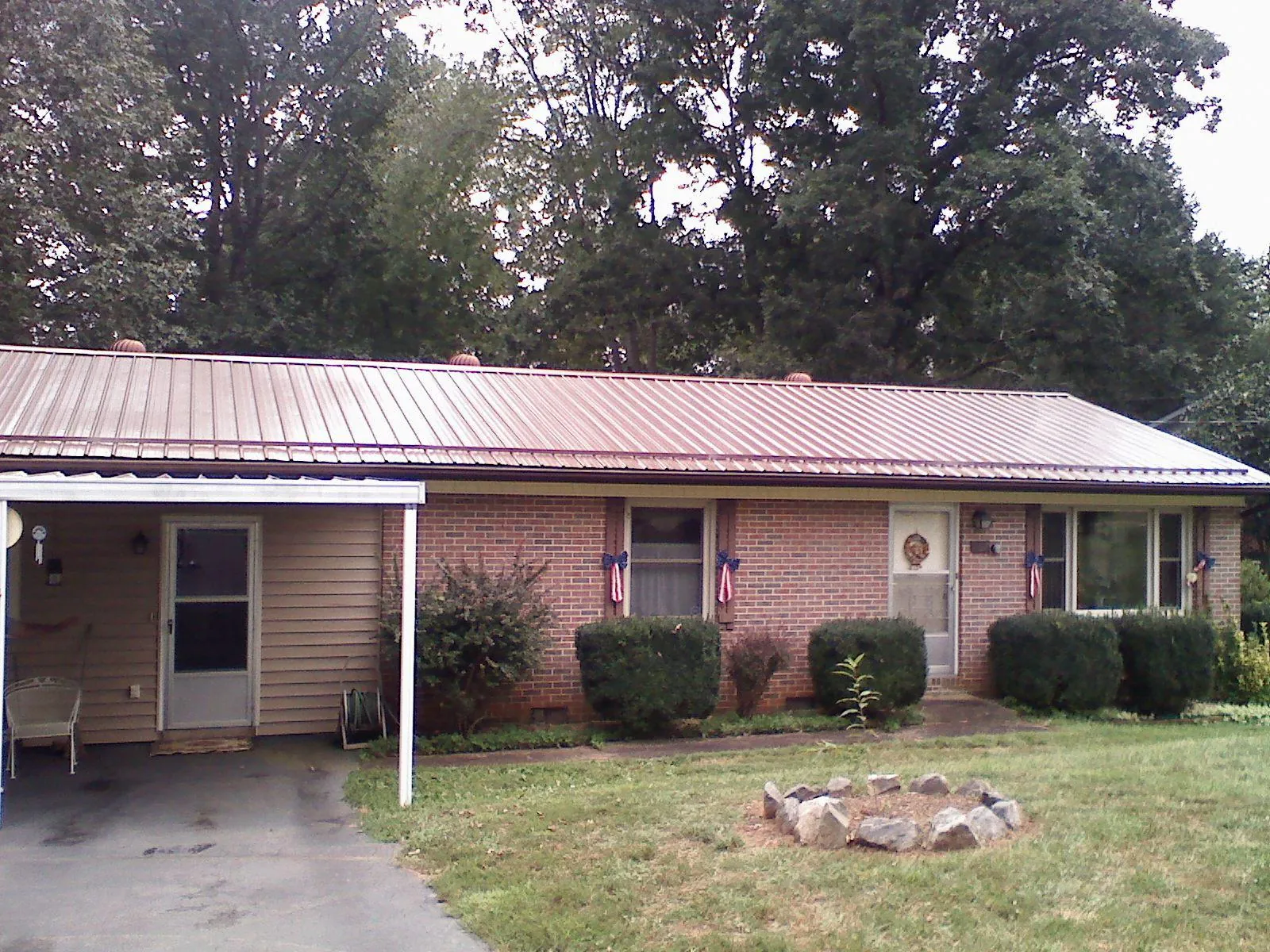 Bronze metal roof and carport on a brick ranch home — Roof Repair work by our crew in Lake Mills